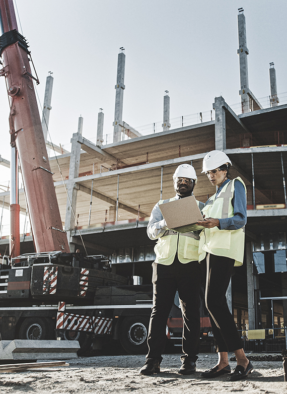 contractors-on-a-jobsite-in-north-carolina-looking-at-a-job-cost-report-on-a-laptop